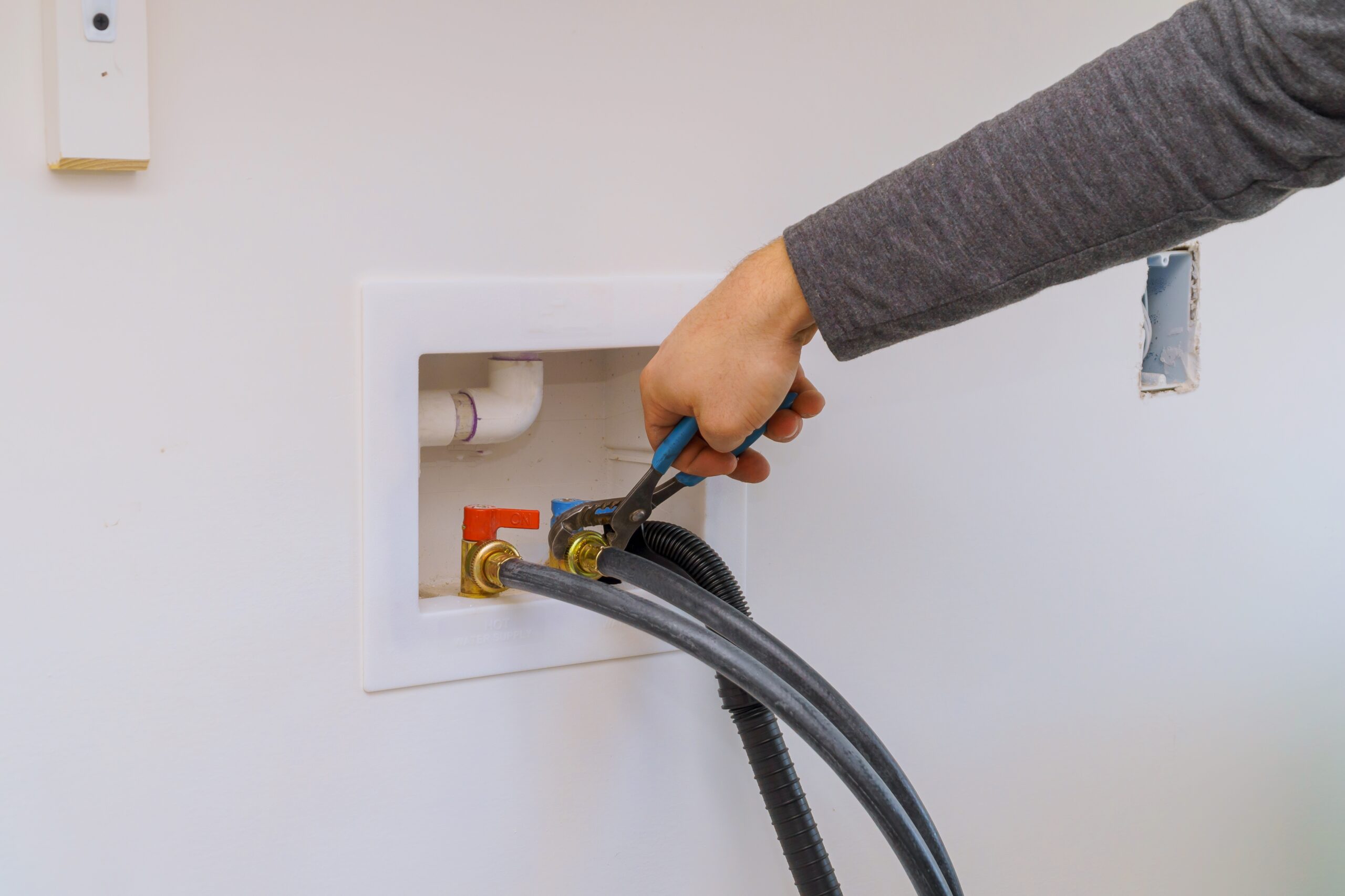 Plumber Installation Hoses to washing machine using wrench